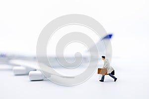 Business Travel and transportation Concept. Close up of businessman traveler miniature figure with baggage running on white