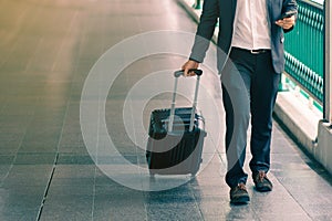 Business traveler pulling suitcase.