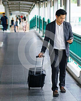 Business traveler pulling suitcase.
