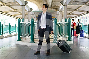 Business traveler pulling suitcase.