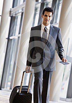 Business traveler pulling suitcase and passport