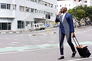 Business traveler walking and talking on mobile phone
