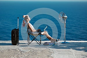 Business travelling, life work balance concept. Woman working on laptop and relaxing on seashore. Lifestyle change idea.