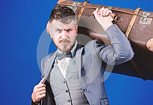 Business trip with retro suitcase. stylish esthete with vintage bag. bearded man in formal suit. heavy bag. mature