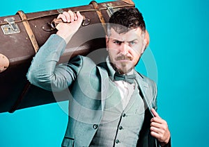 business trip with retro suitcase. stylish esthete with vintage bag. bearded man in formal suit. heavy bag. mature