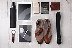 Business trip stuff on light wooden surface, flat lay