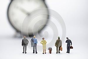 Business Trip and Time Concept. Close up of group of businessman and woman miniature figure people with suitcase standing and look
