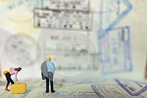 Business Trip and Travel Concept. Businessman and businesswoman miniature figure people standing on passport with immigration