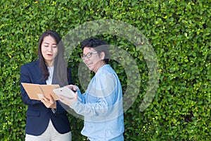 Business two people looking information on tablet corporate digital device.