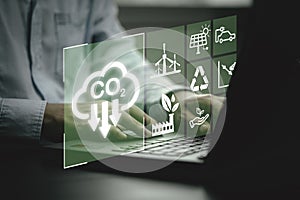 Business using laptop with CO2 reducing icon for new business manage decrease CO2 , carbon footprint and carbon credit to limit