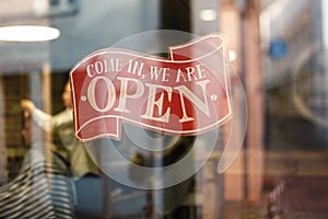 Business vintage sign that says Come in We`re Open on barber and hair salon shop window - Image of abstract blur