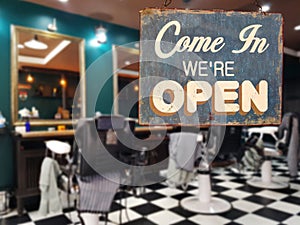 A business vintage sign that says `Come in We`re Open` on barber photo