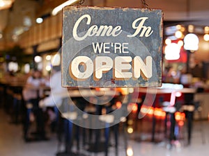 A business vintage sign that says `Come in We`re Open` on Cafe