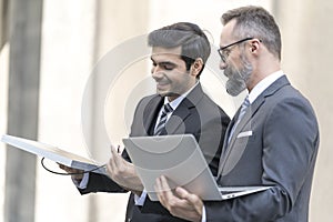 Business where a boss explaining the company strategy to his colleagues. Businessman and attractive Engineer talking and holding