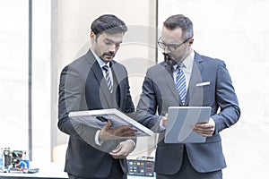 Business where a boss explaining the company strategy to his colleagues. Businessman and attractive Engineer talking and holding