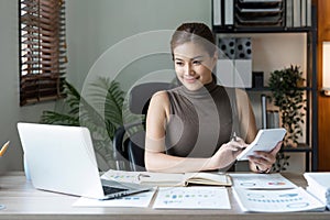 business woman or accountant who are using a calculator to calculate business data Accounting documents and laptop