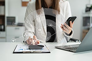 Business woman or accountant working on laptop computer with business document, graph diagram and calculator on office table in