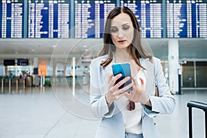 business woman at airport in front of display