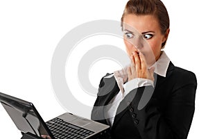 Business woman amazedly looks in laptops screen