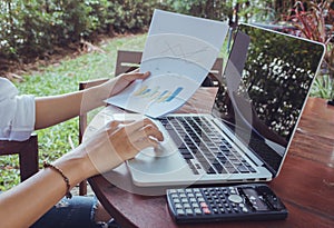 Business woman analyzing graph document financial with laptop vintage tone.