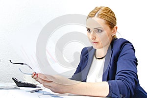 Business woman analyzing investment charts with calculator and laptop