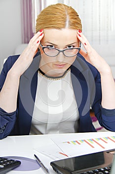 Business woman analyzing investment charts with calculator and laptop