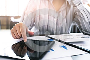 Business woman analyzing investment charts and pressing calculator buttons over documents. Accounting Concept.