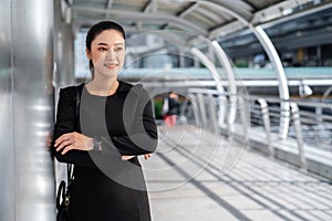 Business woman with arms crossed in city