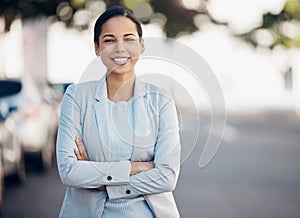 Business woman, arms crossed and confidence portrait in a city with a smile from worker. Young female person