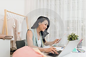 A business woman / Asian fashion designer working at her office / workshop