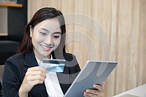 Business woman asian using tablet and credit card shopping online