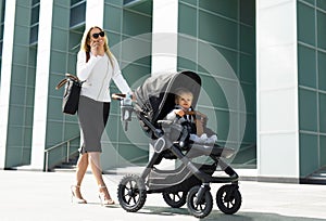 Business woman with baby carriage walking
