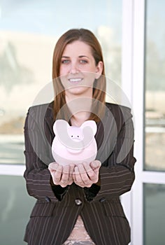 Business Woman and Bank (focus on piggy bank)