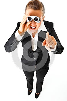 Business woman with binoculars pointing finger