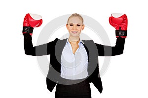 Business woman in boxing gloves standing in victory pose