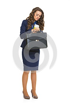 Business woman with briefcase looking on watch