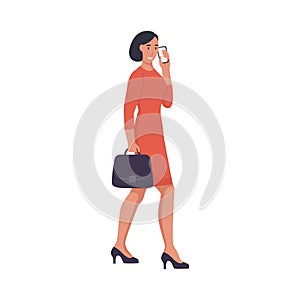 A business woman with a briefcase is talking on the phone and walking down the street