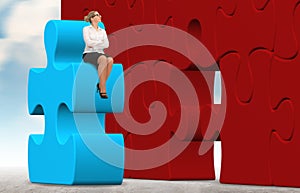 Business woman building a puzzle on a sky background.