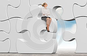 Business woman building a puzzle on a sky background.