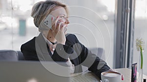 Business woman in a cafe talking on the phone.