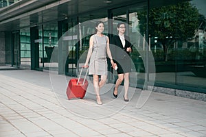 Business woman carring suitcase walk along assistant