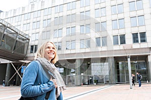 Business woman in casual clothes walking down the street in front of a business center