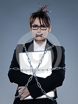 Business woman chained to her her computer laptop