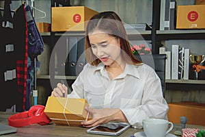 Business woman check product and orders vis tablet, with cardboard box packaging,online selling with start up and small business,
