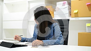 Business woman checking bills and doing budget with calculator