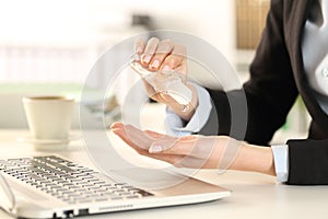 Business woman cleaning hands with sanitizer in the office