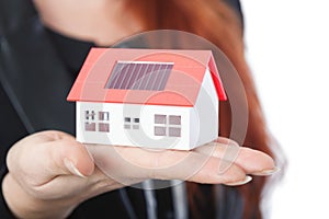 Business woman with close up of mini solar house