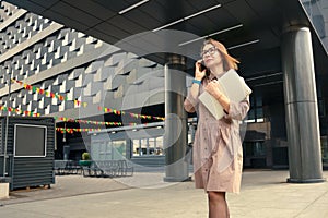 Business woman with computer on the background of a modern building