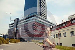 Business woman with computer on the background of a modern building