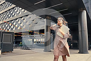 Business woman with computer on the background of a modern building